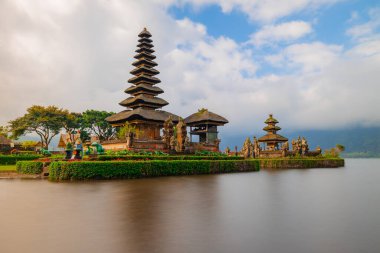 Bali adasındaki Pura Ulun Danu Bratan tapınağı. Güzel bale tapınağı. Bali 'nin simgesi. Bulutlu gökyüzü. Su yansıması. Kapama hızı yavaş. Bratan Gölü, Bali, Endonezya