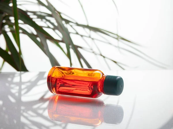 Amber red medical bottle isolated on white background with leaf. Copy space