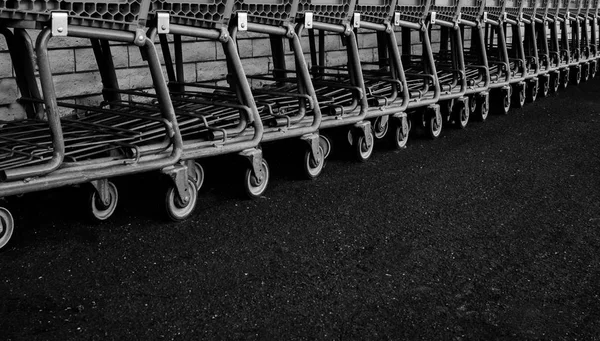 Eski paslı alışveriş arabaları geri dönüşüm için mağaza arkasında bir tuğla duvar boyunca sıralanır. Siyah ve beyaz fotoğraf üzücü bir duygu gibi onlar değerli ve ihmal hissediyorum verir. Yaş kendi yarar azalır ve yeni arabaları ile değiştirildi