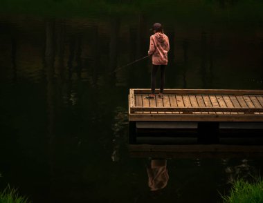 Sabah erken saatlerde genç bir kız tek başına bir rıhtıma balıkçılık yapıyor. Hala çoğunlukla ağaçların gölgesinde ve kendisi gölün karanlık sakin suyuna yansıtmaktadır. Döküm ve onun cazibesini alma o beklenen ısırık üzerinde yoğunlaşır.