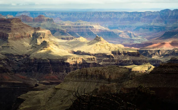 Grand Canyon Ulusal Parkı Arizona Abd. Kısa süreli güneş ışığı milleri, yüksek kontrastrenkleri sağlayan manzarayı aydınlattı. Kanyonu oyulmuş Colorado Nehri arka planda görülebilir..