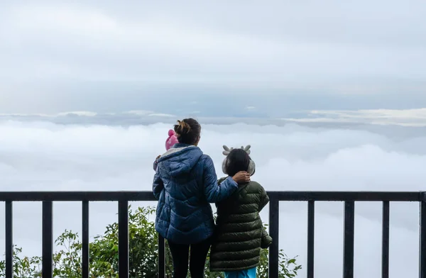 Мать с дочерью и маленькой дочерью путешествуют в горах, глядя на туман . — стоковое фото