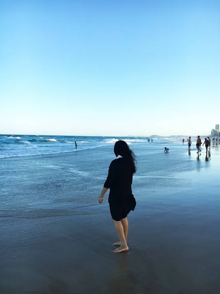 Lady Gold Coast, Avustralya sahilde yalınayak yürüyüş ve tropikal esinti ve sıcak gün batımı zevk