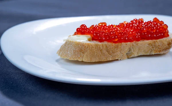 Sandwich con caviar rojo en un plato —  Fotos de Stock