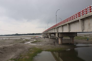 Uzun beton köprü. Karanlık bulutlu bir gökyüzü boyunca uzanan yüksek beton bir otoyol. Şehirdeki gri kirişin altındaki manzara..