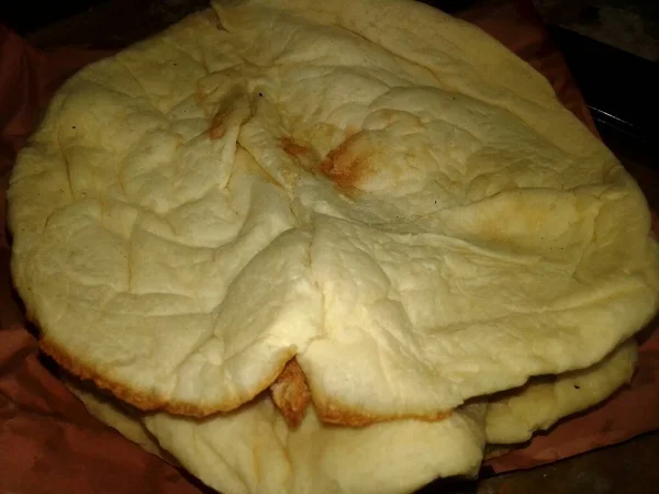 Naan Ekmeği Yakından Fotoğraf Yakala. Tandır Naan. Bangladeş ve Hint Naan Roti. Naan, Güney Asya, Batı Asya 'da bulunan mayalanmış, fırında pişirilmiş bir ekmek türüdür..