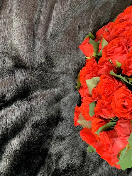Brown fur background. Bouquet of red roses on a brown background.