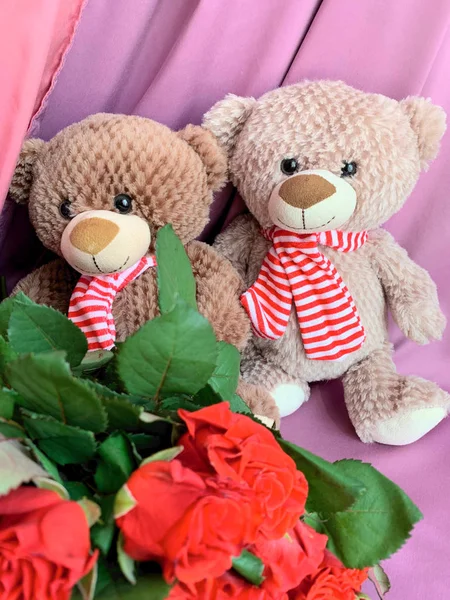 Teddy bear with a bouquet of red roses.