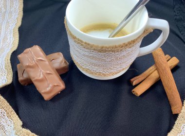 Siyah bir arka plan üzerinde beyaz bir fincan kahve bir fincan, çikolata.