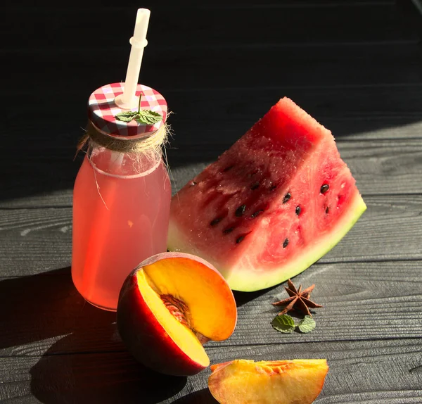 Karpuz ve şeftali şişesinden yapılmış vejetaryen içeceği. Siyah bir arka planda, meyve dolu bir hayat..
