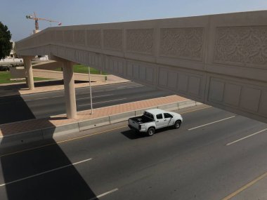 Köprüden geçen yayalar için üstgeçit manzaralı bir köprü ve bir araba çok hızlı gidiyor.