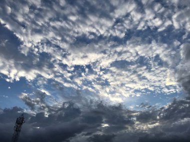 Gökyüzü ya da evren üzerinde mavi arkaplanı olan beyaz bulutlar güzel görünüyor ve güzel bir akşamda gün batımında görüntüleniyor.