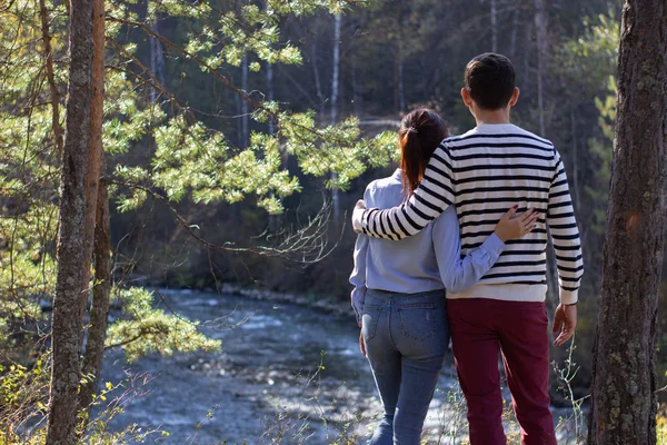 Un chico y una chica están al aire libre mirando al frente. Vista trasera —  Fotos de Stock