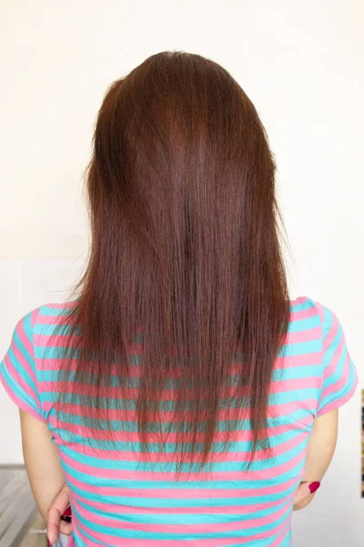 Lange weibliche Haare kastanienbraun hinter dem Mädchen — Stockfoto