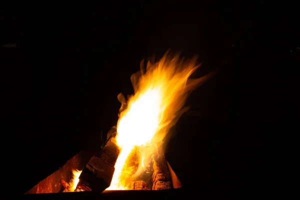 O fogo arde na grelha à noite. Fogo brilhante, madeira. as chamas na noite — Fotografia de Stock