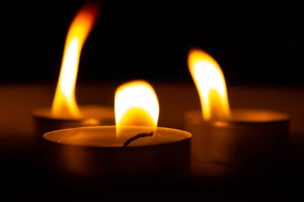 three candles in the dark, close up.