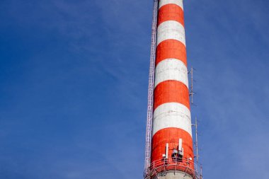 Mavi gökyüzüne karşı kırmızı ve beyaz eski tuğla endüstriyel boru