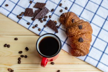 Ahşap bir arka planda kahve ve kruvasan. Yukarıdan manzara. Kahve çekirdeği