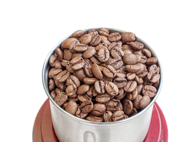 A lot of coffee beans in a metal coffee grinder on a white background