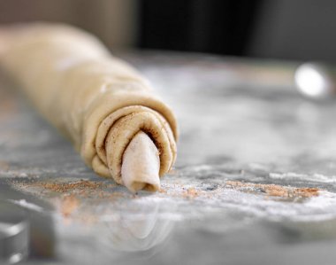 Fırındaki bir kabın üzerinde tarçınlı hamur rulosu. Çörek pişiriyorum..