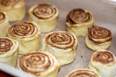 Fırındaki bir kabın üzerinde tarçınlı hamur rulosu. Çörek pişiriyorum..