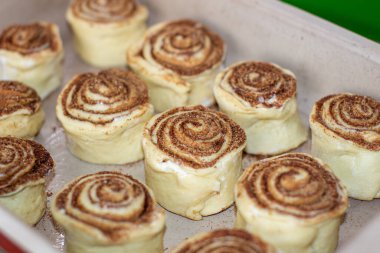 Fırındaki bir kabın üzerinde tarçınlı hamur rulosu. Çörek pişiriyorum..