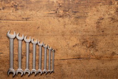 Eski ahşap bir arka planda İngiliz anahtarı seti.