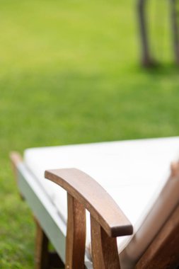 Yazın özel bahçedeki çimlerin üzerinde tahta güneş yatağı