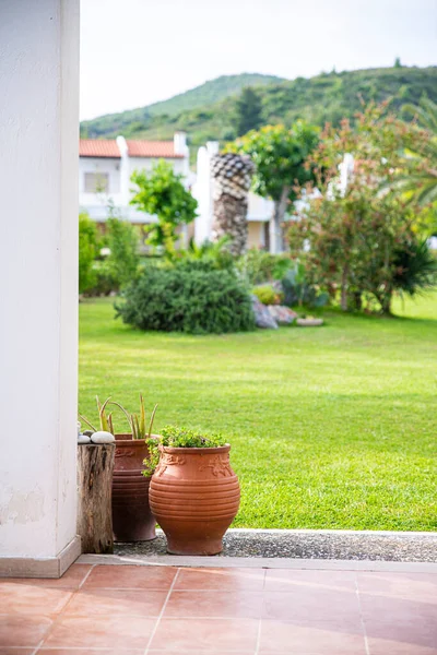 Ancient Greek flower pot with a garden view in summer