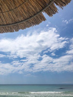 Saman Şemsiyesi ve Gökyüzü Yaz Zamanı Bulutlarla Sahilde