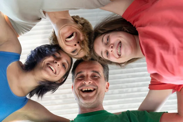 Family Laughing and Having Fun Together. Low Angle View of a Family With Their Head Forming a Circle