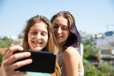 Cep telefonuyla selfie çeken iki genç kız. Ev Kavramı
