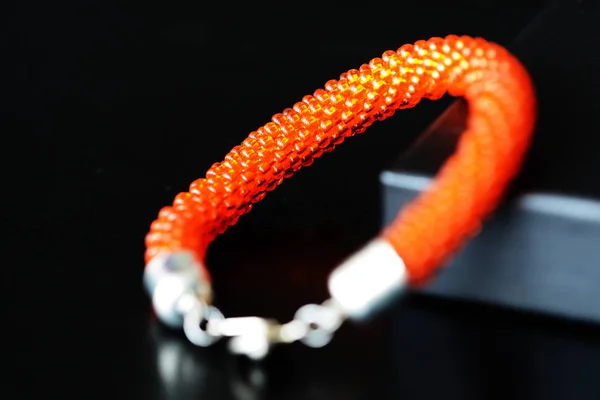 橙色珠子手镯由透明种子珠在黑暗的背景特写 — 图库照片