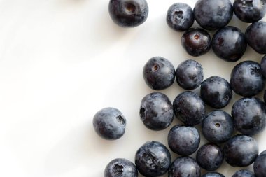 Beyaz bir tabakta taze yaban mersini yakından. Üstte görüntü