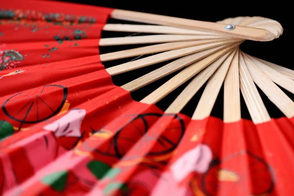 Bright vietnamese fan spread out on a dark background close-up