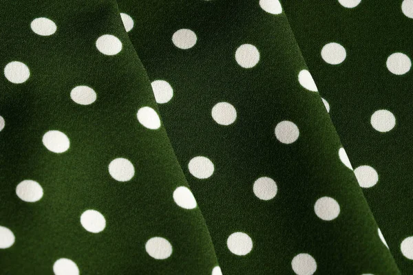 Green and white polka dot textile close up. Abstract background