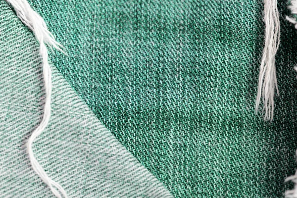 Old jeans texture close up. Green denim background