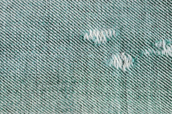 Old jeans texture close up. Green denim background