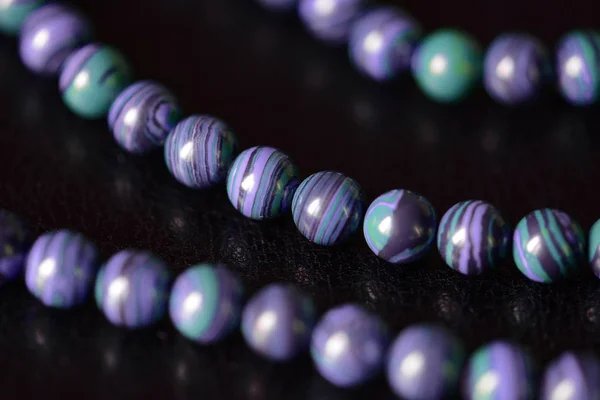 Malachite stone beads necklace on a dark background close up