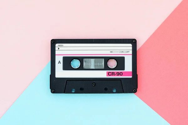 Old audio tape cassette on a multicolor background. Top view, old technology concept