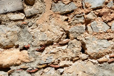 Parlak güneş yakın çekim tarafından aydınlatılmış eski bir duvarın parçası. Taş duvar arka planı.