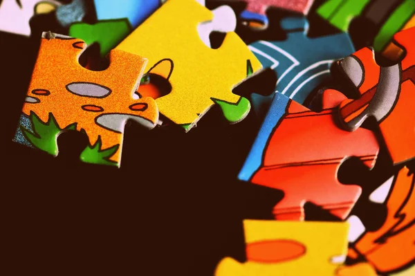 Children's puzzles on a dark background close up. Retro style toned — ストック写真