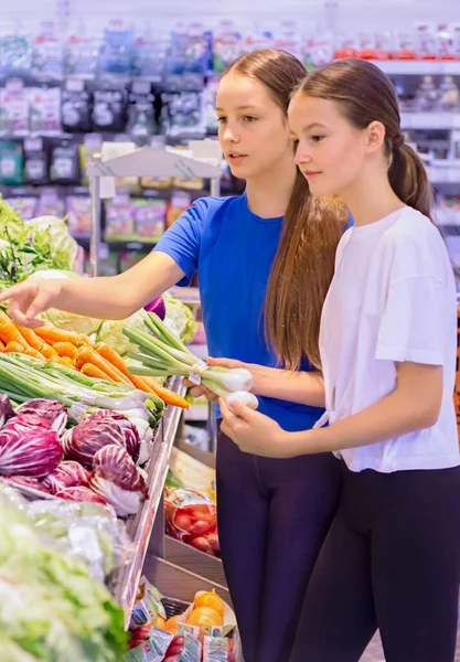 슈퍼마켓에서 쇼핑을 정보를 매일의 상품을 선택하는 소녀들 대들의 음식에 의식적 — 스톡 사진