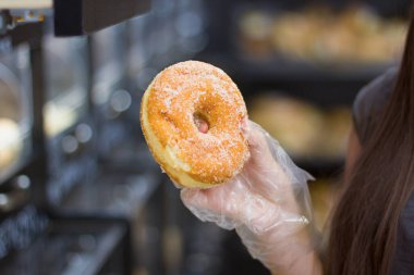 Kadın eli süpermarkette ekmek seçiyor.