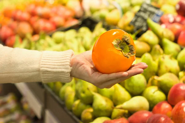 Kobieca Ręka Persimmon Supermarkecie Pojęcie Zdrowej Żywności Bio Wegetariańskie Dieta — Zdjęcie stockowe