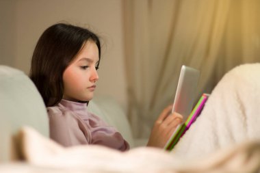 Okul için ödev yapan genç tablet hakkında araştırma yapıyor.