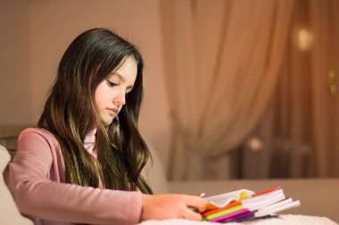 Okul için ödev yapan genç bir kız..