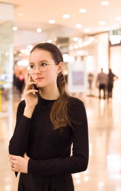 Genç kız telefonda konuşuyor.