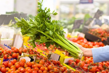 Markette kereviz seçen bir kadın. Sağlıklı gıda kavramı, biyoloji, vejetaryen, diyet.