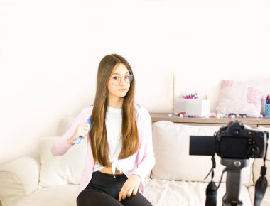 Genç kız blogcu güzellik ürünlerini sunuyor, tarıyor ve sosyal ağlara canlı yayın yapıyor. Genç blogcu kızların etkilerine odaklan. Güzellik blogcusu ve vlog konsepti.